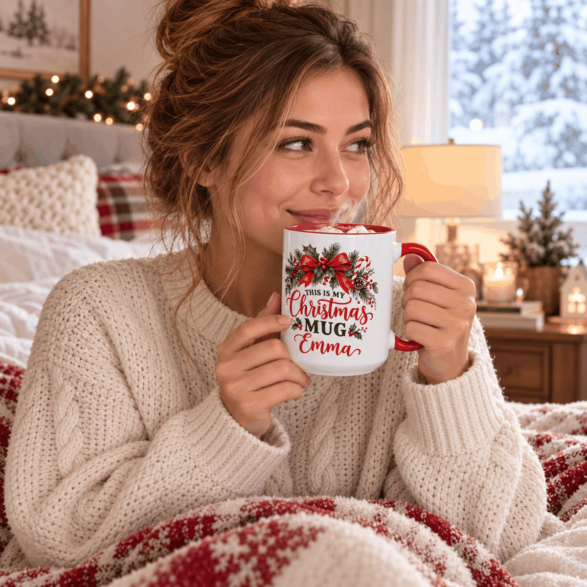 Lifestyle mockup: woman enjoying a warm drink with her personalized Emma Christmas mug in a cozy winter bedroom.