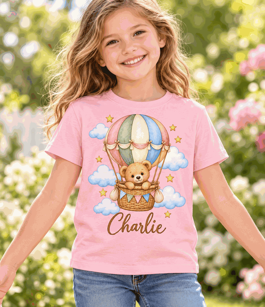 Illustrative mockup: child wearing pink personalized teddy bear balloon T-shirt – Charlie sample name