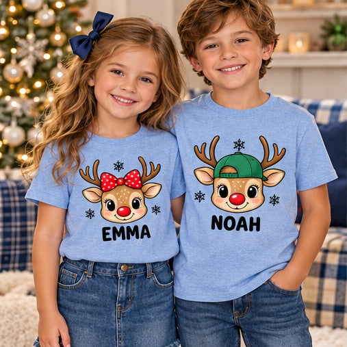Children wearing blue personalized reindeer head T-shirts. Each tee sold separately; names shown are samples.