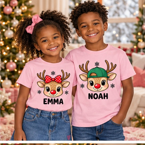Children wearing pink personalized reindeer head T-shirts. Each tee sold separately; names shown are samples.