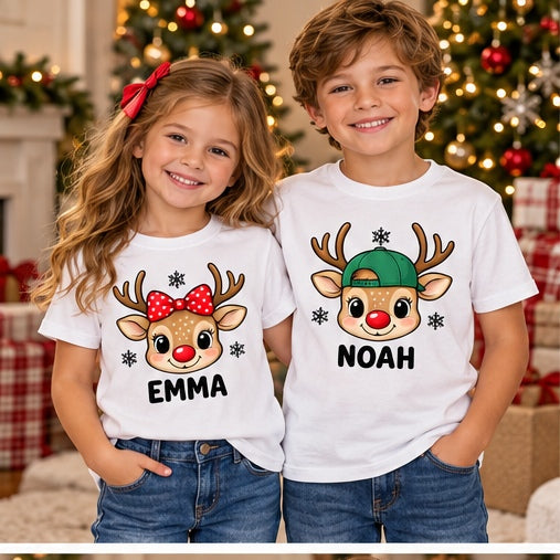 Children wearing white personalized reindeer head T-shirts. Each tee sold separately; names shown are samples.